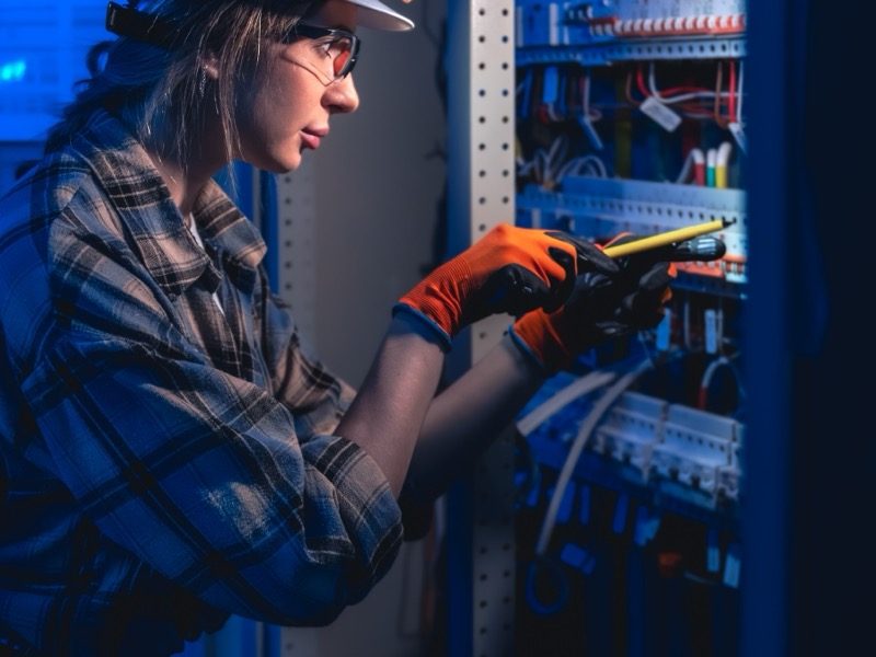 Technikerin bei der wiederkehrenden Prüfung einer Verteilung